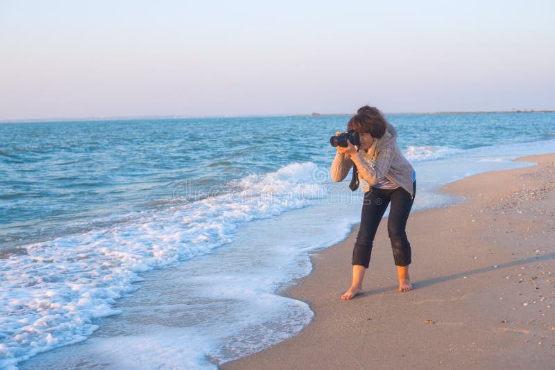 Un fotografo femminile entusiasta prende un'immagine fotografia stock Un fotografo femminile entusiasta prende un'immagine fotografia stock