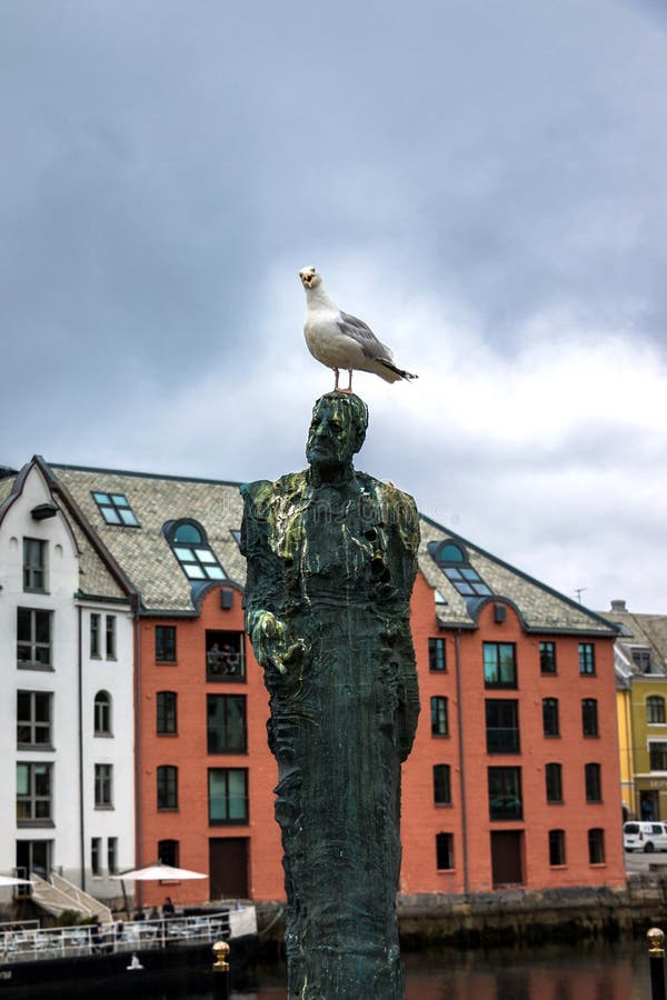 Un gabbiano curioso sulla testa di una statua dell'uomo immagine stock libera da diritti Un gabbiano curioso sulla testa di una statua dell'uomo immagine stock libera da diritti