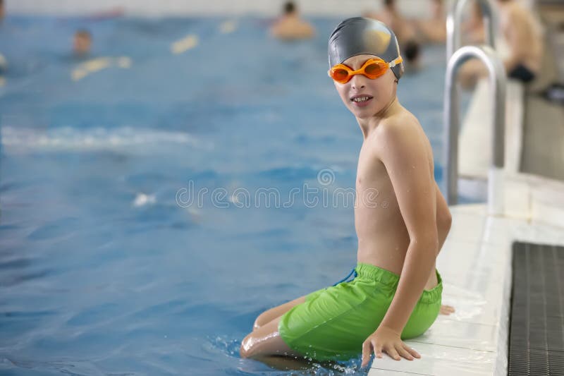 Un Garçon Dans Une Casquette De Natation Et Des Lunettes Est Assis Image  stock - Image du capuchon, plongée: 293658701