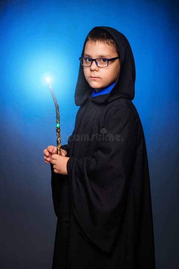 Un Garçon Sorcier Dans Des Lunettes Avec Une Baguette Magique Dans Les  Mains Et Dans Une Robe Noire Avec Une Capuche évoque Un Sor Photo stock -  Image du bleu, fée: 208868274