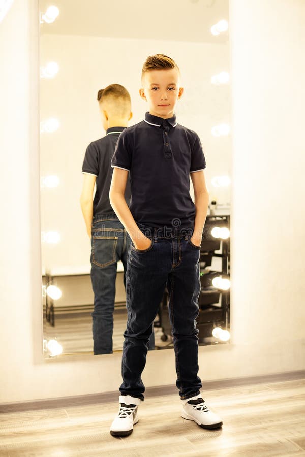 Un Garcon De 10 Ans Chez Un Coiffeur Apres Une Coupe De Cheveux a La Mode Devant Un Miroir. Un Petit Enfant Dans Un Salon De Beaut Photo stock Image du