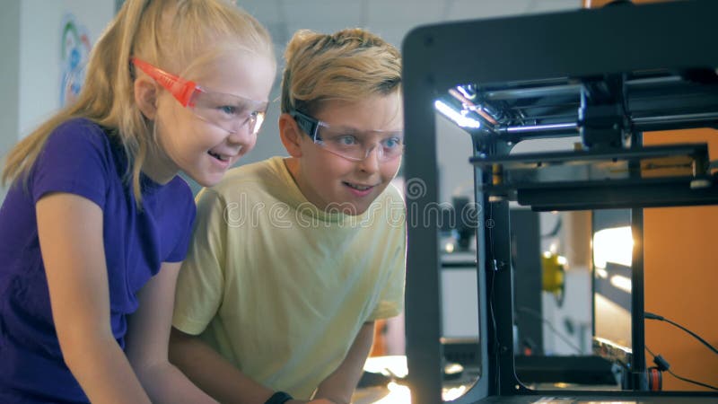 Un garçon et une fille sont excités au sujet du cours d'une expérience technologique