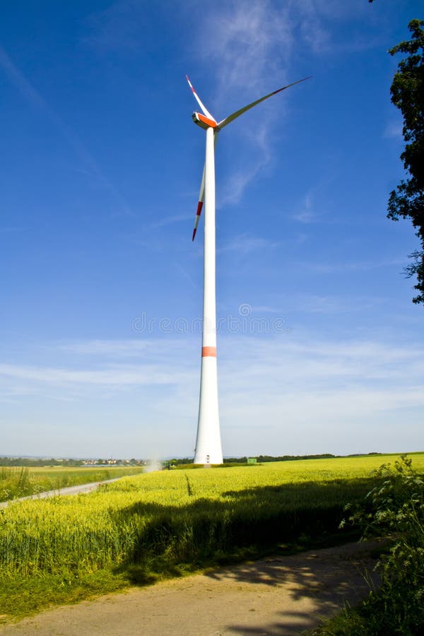Un generatore eolico su un campo verde da dietro Fotografato in Baviera, la Germania immagine stock libera da diritti Un generatore eolico su un campo verde da dietro Fotografato in Baviera, la Germania immagine stock libera da diritti