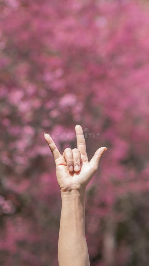 Un giovane alza le mani sopra la testa e usa il linguaggio dei segni per simboleggiare io ti amo per raccontare al suo amante i su immagini stock libere da diritti