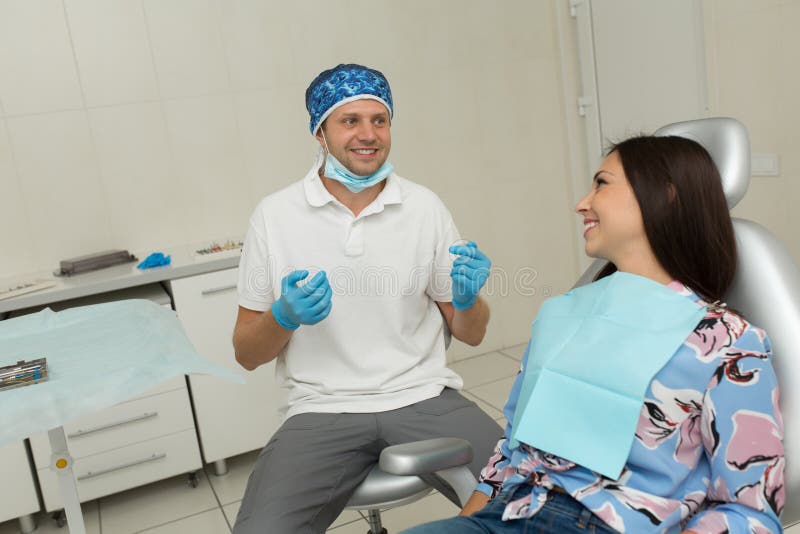 Un giovane dentista maschio e un paziente femminile felice Scena di stile di vita dell'ufficio del dentista Pratica di medico San immagine stock Un giovane dentista maschio e un paziente femminile felice Scena di stile di vita dell'ufficio del dentista Pratica di medico San immagine stock