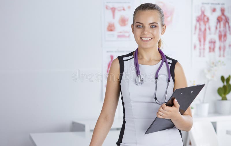 Un giovane medico femminile ad uno scrittorio nell'ufficio Il concetto della h fotografia stock libera da diritti Un giovane medico femminile ad uno scrittorio nell'ufficio Il concetto della h fotografia stock libera da diritti