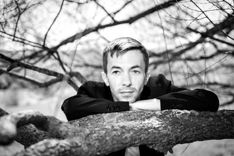 Un giovane si è appoggiato il ramo dell'albero Ho messo la mia testa sui miei gomiti fotografie stock Un giovane si è appoggiato il ramo dell'albero Ho messo la mia testa sui miei gomiti fotografie stock