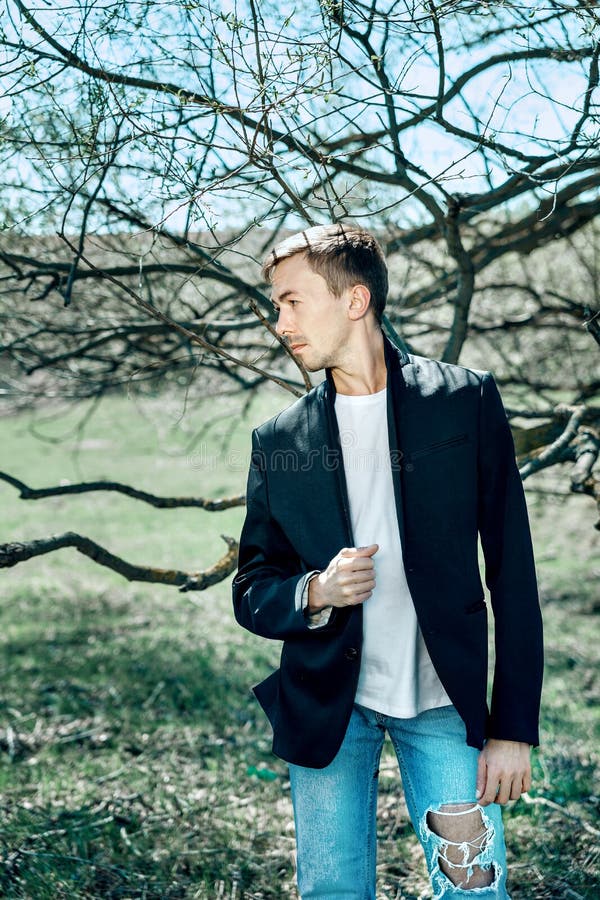 Un giovane uomo attraente in maglietta bianca e blue jeans immagini stock libere da diritti Un giovane uomo attraente in maglietta bianca e blue jeans immagini stock libere da diritti