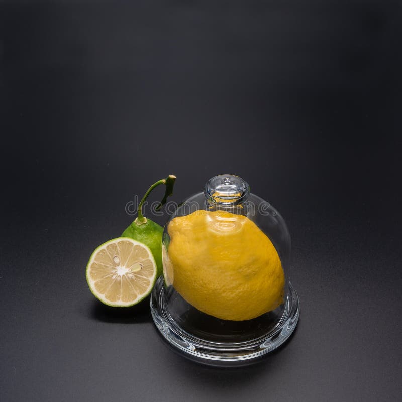 Un gran limón amarillo fresco está en un recipiente de vidrio transparente. imagenes de archivo