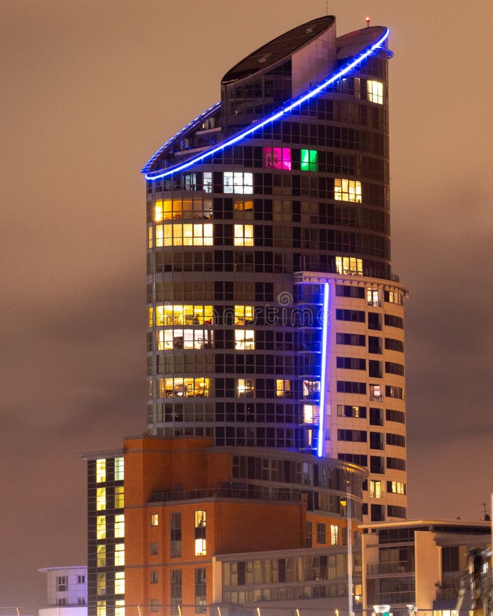 Un grand immeuble moderne éclairé la nuit image stock Un grand immeuble moderne éclairé la nuit image stock