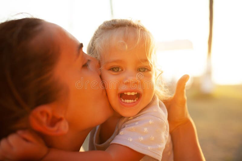Un grand portrait, mère embrasse sa fille dans les rayons du coucher de soleil Valeurs familiales, enfant heureux images libres de droits Un grand portrait, mère embrasse sa fille dans les rayons du coucher de soleil Valeurs familiales, enfant heureux images libres de droits