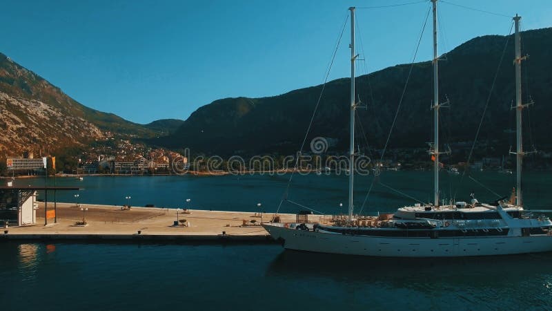 Un grande yacht sta al pilastro nella baia Cattaro, Montenegro Metraggio aereo