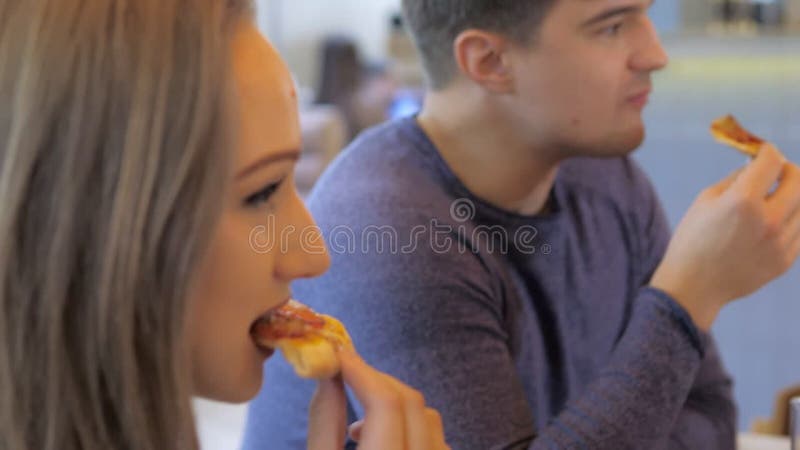 Un groupe d'amis heureux s'installe à table dans un restaurant cosy riant et s'amusant. un groupe de filles et d'hommes banque de vidéos