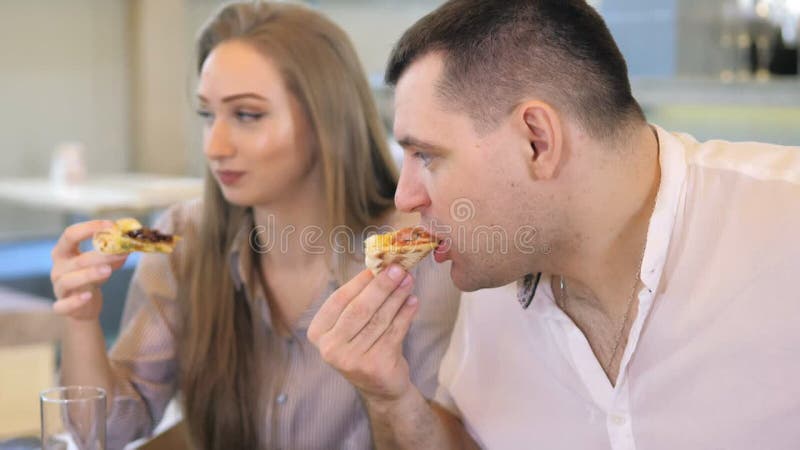Un groupe d'amis heureux s'installe à table dans un restaurant cosy riant et s'amusant. un groupe de filles et d'hommes banque de vidéos