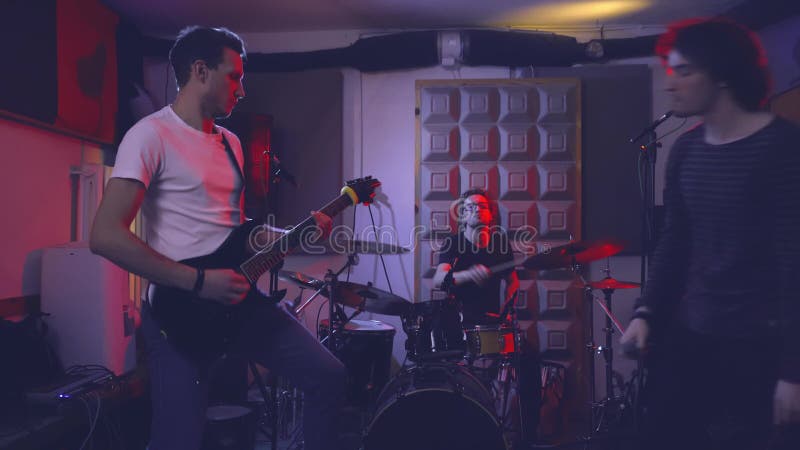 Un groupe d'amis musiciens guitariste et tambour chanteur dans le garage clips vidéos