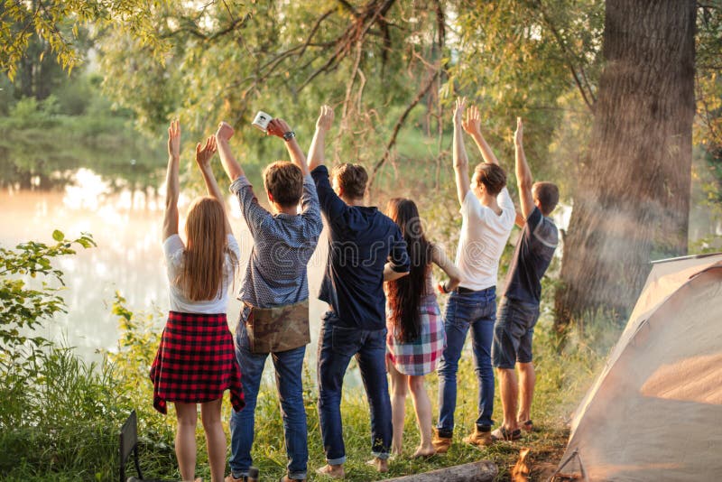 Un groupe d'amis sympathiques saluent le lever du soleil image libre de droits