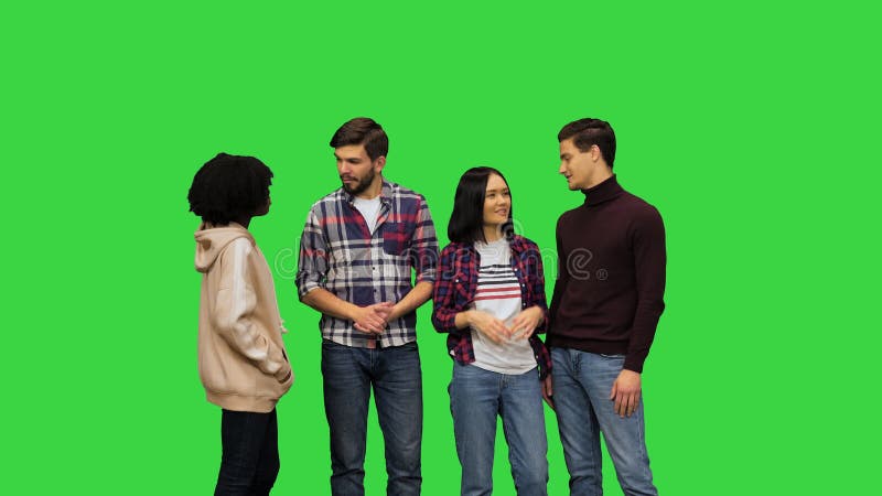 Un groupe de jeunes filles et garçons ayant une conversation joyeuse riant souriant commérage sur un écran vert chroma banque de vidéos