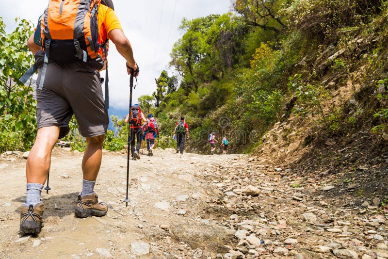 Un groupe de personnes trekking sur le chemin de terre au Népal photographie stock libre de droits Un groupe de personnes trekking sur le chemin de terre au Népal photographie stock libre de droits