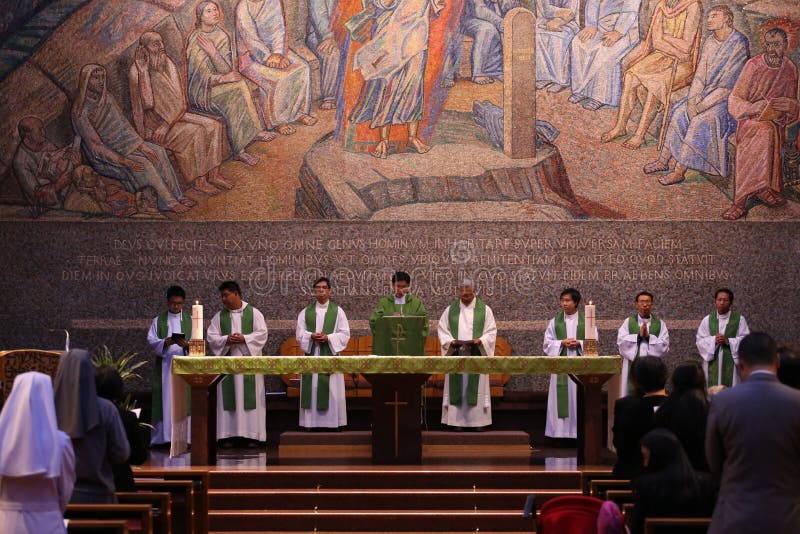 Un groupe de prêtres catholiques et de soeurs dans la masse sainte