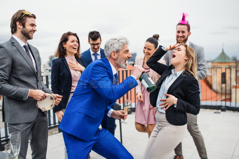 Un grupo de empresarios alegres que tienen un aire libre del partido en terraza del tejado en ciudad imagenes de archivo Un grupo de empresarios alegres que tienen un aire libre del partido en terraza del tejado en ciudad imagenes de archivo