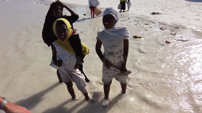 Un grupo de niños africanos extorsionan en una playa de zanzíbar áfrica.