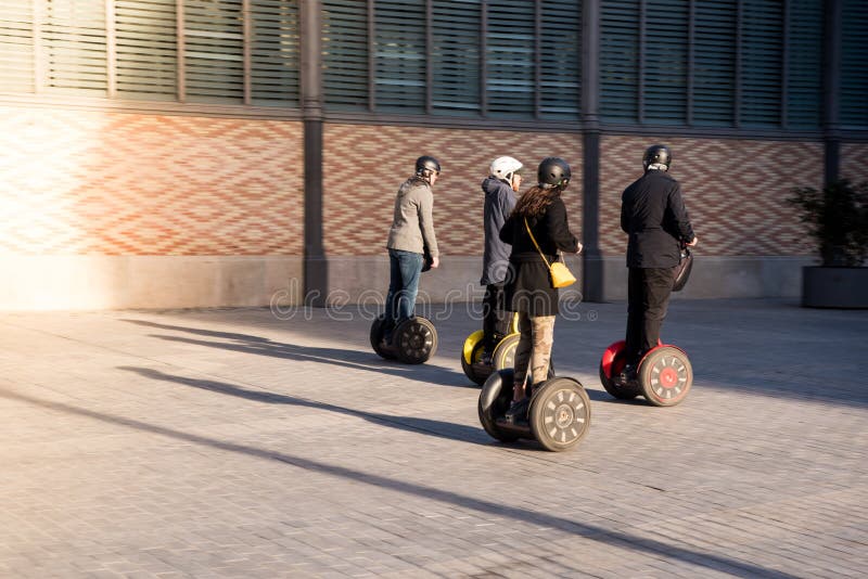 Un grupo de personas en motos Segway respetuosas con el medio ambiente en una calle histórica de España Turistas disfrutando de m imagen de archivo libre de regalías Un grupo de personas en motos Segway respetuosas con el medio ambiente en una calle histórica de España Turistas disfrutando de m imagen de archivo libre de regalías