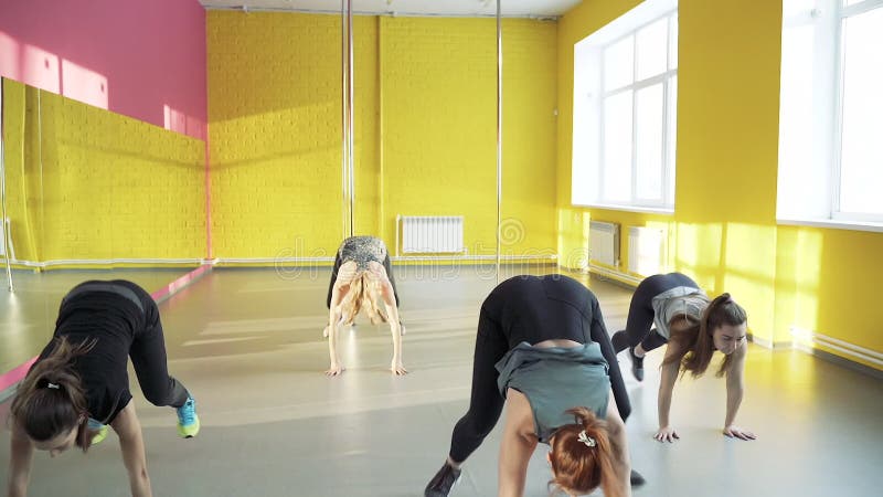 Un gruppo di giovani atletiche fa esercizi di rutturazione nello studio di fitness