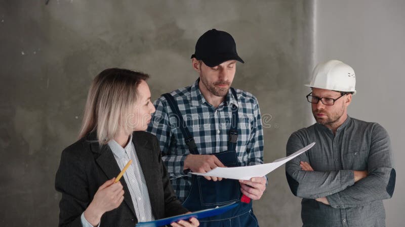 Un gruppo di operai edili si stanno accanto in una stanza stock footage