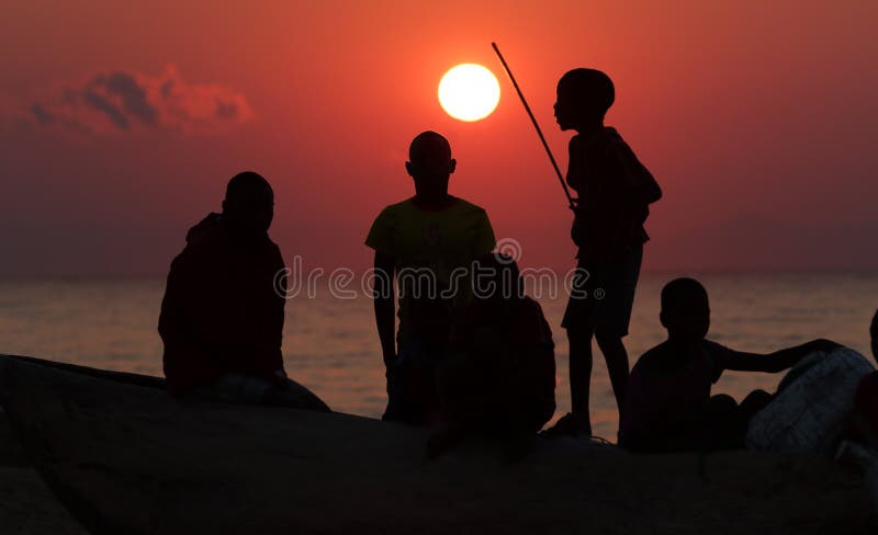 Un gruppo di pescatori e di bambini ad alba, il lago Malawi immagini stock libere da diritti Un gruppo di pescatori e di bambini ad alba, il lago Malawi immagini stock libere da diritti