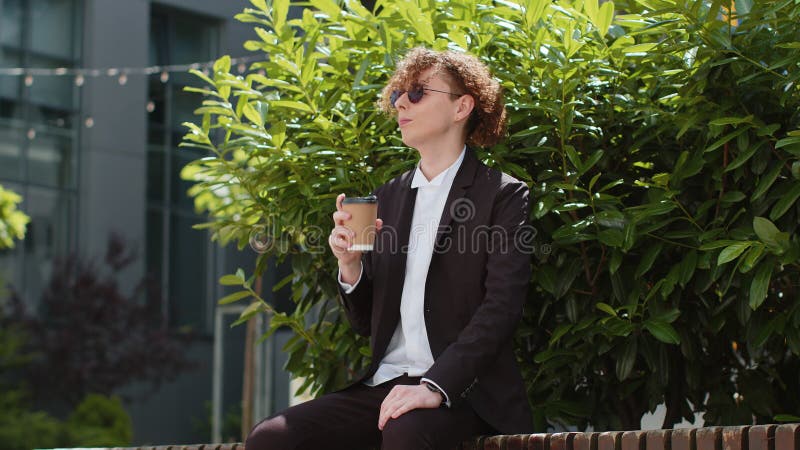Un heureux homme d'affaires caucasien dégustant un café chaud en plein air en se reposant banque de vidéos