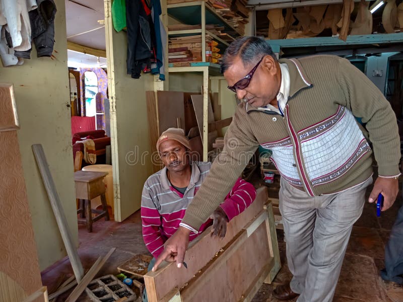 un hombre asiático dando instrucciones al carpintero para hacer acabados de muebles en el taller en India enero de 2020 imágenes de archivo libres de regalías un hombre asiático dando instrucciones al carpintero para hacer acabados de muebles en el taller en India enero de 2020 imágenes de archivo libres de regalías