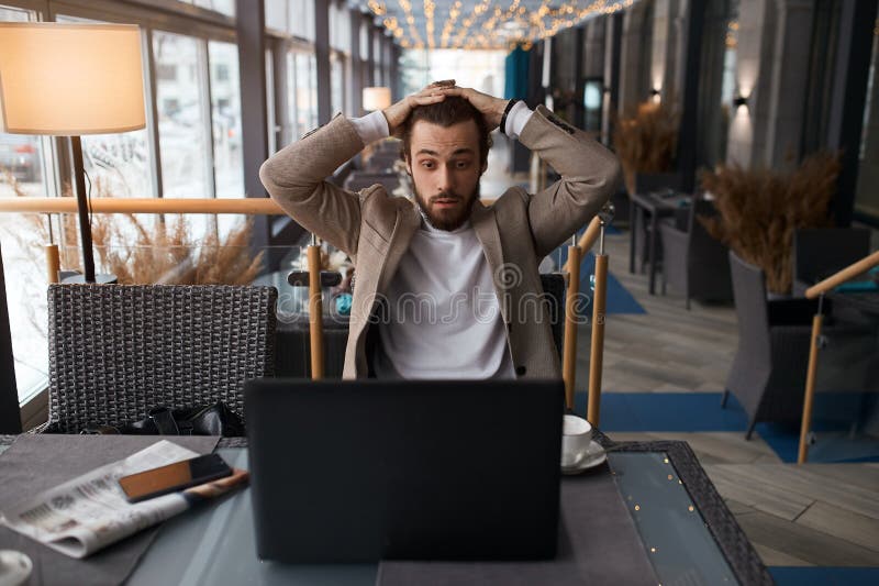Un hombre confundido que resuelve problemas de negocios no puede arreglar el computador foto de archivo libre de regalías