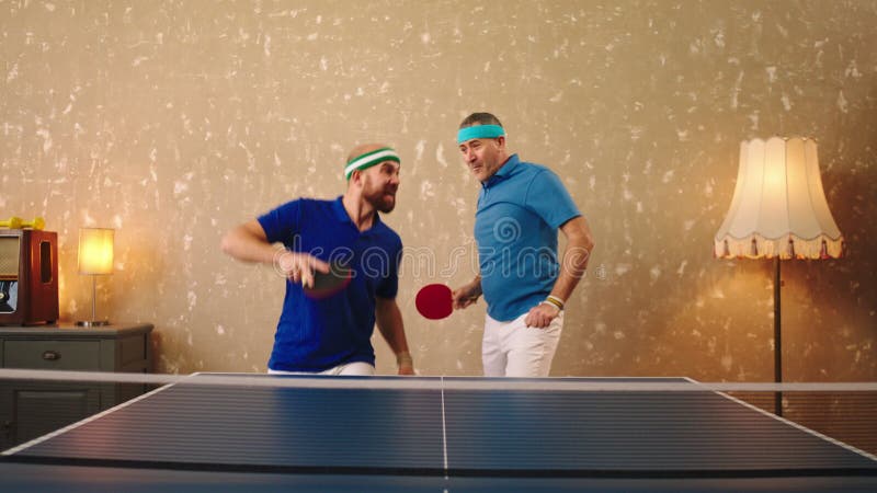 Un hombre de buen aspecto y un joven jugando juntos como un equipo en el ping pong ganan el juego metrajes
