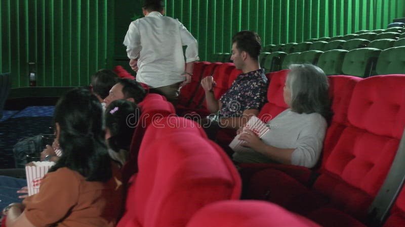 Un hombre de edad avanzada camina al asiento del teatro e interrumpe a otra audiencia.