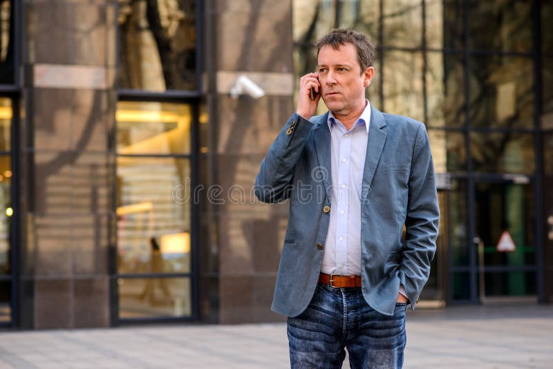 Un hombre de negocios de la Edad Media con un teléfono fotografía de archivo libre de regalías Un hombre de negocios de la Edad Media con un teléfono fotografía de archivo libre de regalías