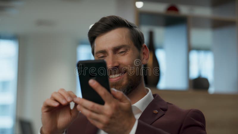 Un hombre de negocios que se ríe hablando un smartphone en el armario. llamada final del administrador almacen de video
