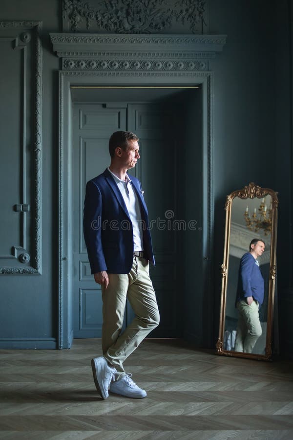Un Hombre Elegante Y Con Una Chaqueta Azul En Casa Mirando a Lado Imagen de archivo - de adulto, ropa: