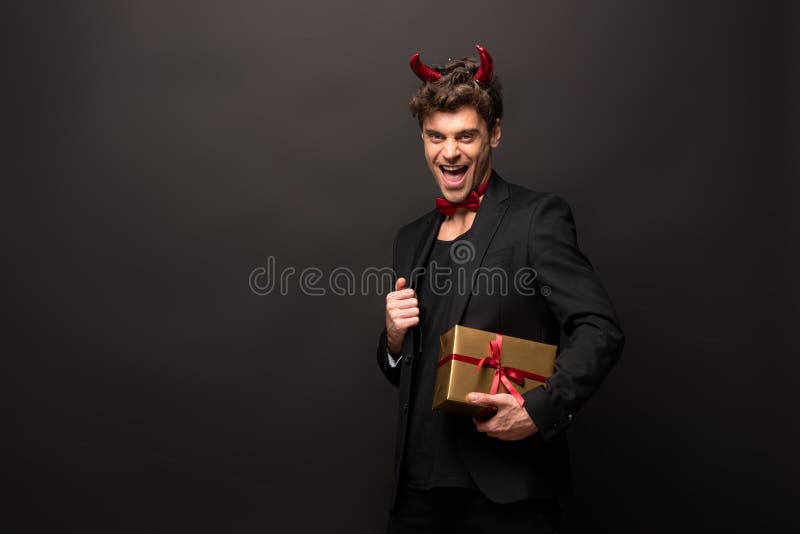 Un Hombre Emocionado Disfrazado De Demonio Sosteniendo Cajas De Regalo Para Halloween En Negro Imagen de archivo - Imagen de asustadizo, octubre: 189539517 Un Hombre Emocionado Disfrazado De Demonio Sosteniendo Cajas De Regalo Para Halloween En Negro Imagen de archivo - Imagen de asustadizo, octubre: 189539517