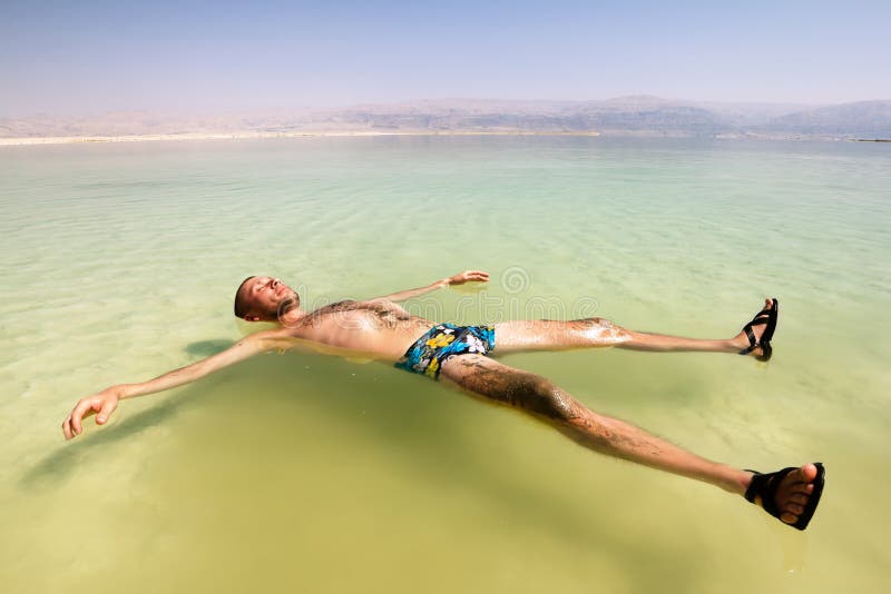 Un hombre en el agua del mar muerto en Israel Un hombre en el agua del mar muerto en Israel