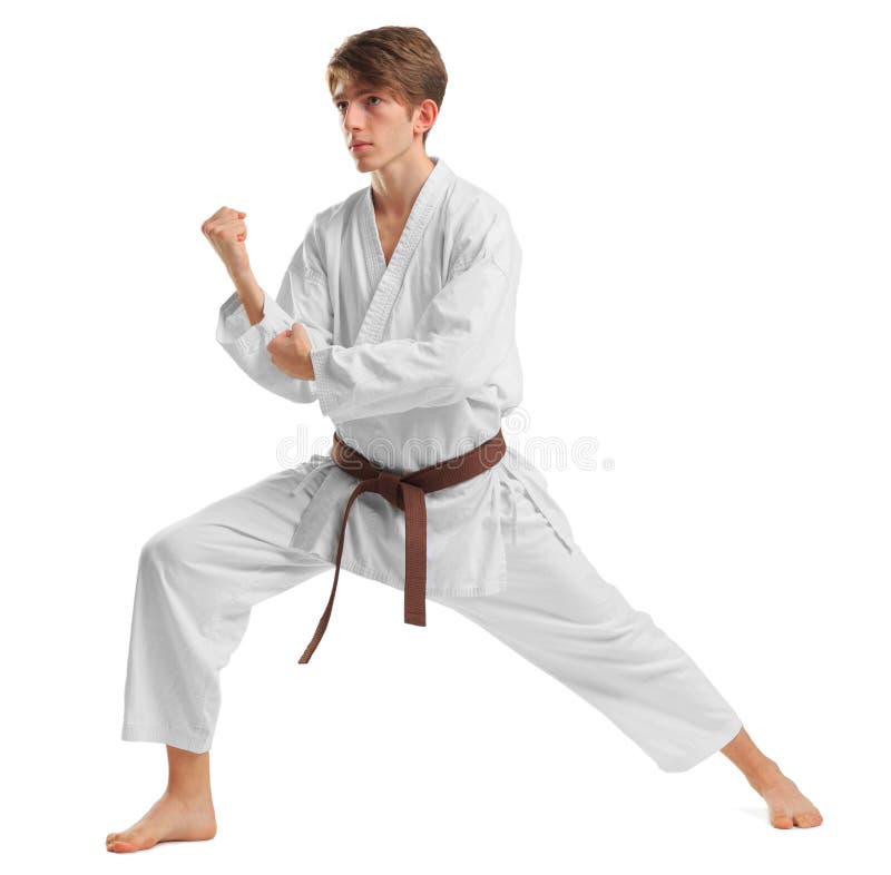 Un hombre en un kimono en una postura que lucha en un fondo blanco aislado foto de archivo Un hombre en un kimono en una postura que lucha en un fondo blanco aislado foto de archivo