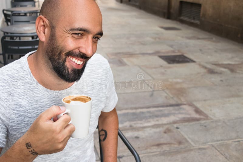 Un hombre español que sonríe comiendo café al aire libre foto de archivo Un hombre español que sonríe comiendo café al aire libre foto de archivo