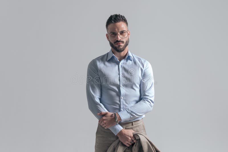Un hombre guapo sin afeitar que lleva gafas y una chaqueta fotografía de archivo