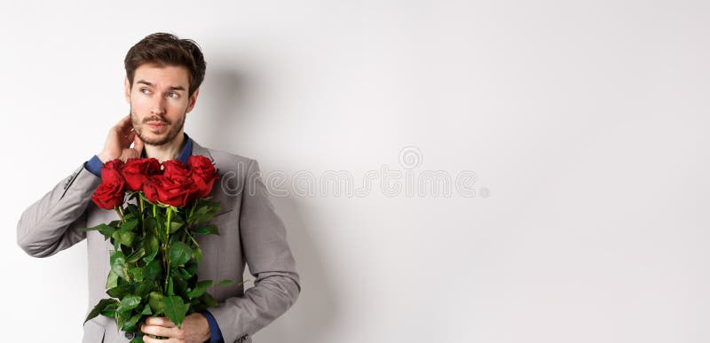 Romance de san valentín. hombre joven con ramo de rosas rojas y