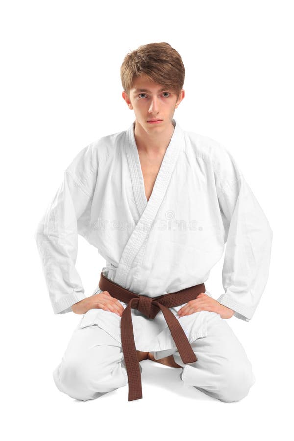 Un hombre joven en un kimono que se sienta en una actitud del loto imagen de archivo Un hombre joven en un kimono que se sienta en una actitud del loto imagen de archivo