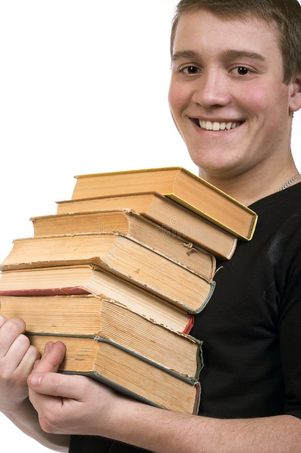 Un hombre joven lleva una pila de libros foto de archivo libre de regalías Un hombre joven lleva una pila de libros foto de archivo libre de regalías