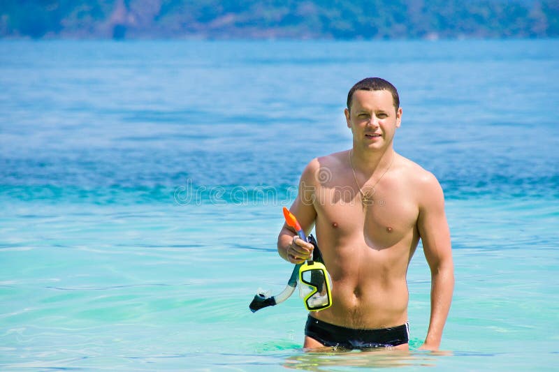 Un hombre joven que sale del mar despu?s de nadar Individuo feliz el vacaciones Un hombre camina la costa imagenes de archivo Un hombre joven que sale del mar despu?s de nadar Individuo feliz el vacaciones Un hombre camina la costa imagenes de archivo