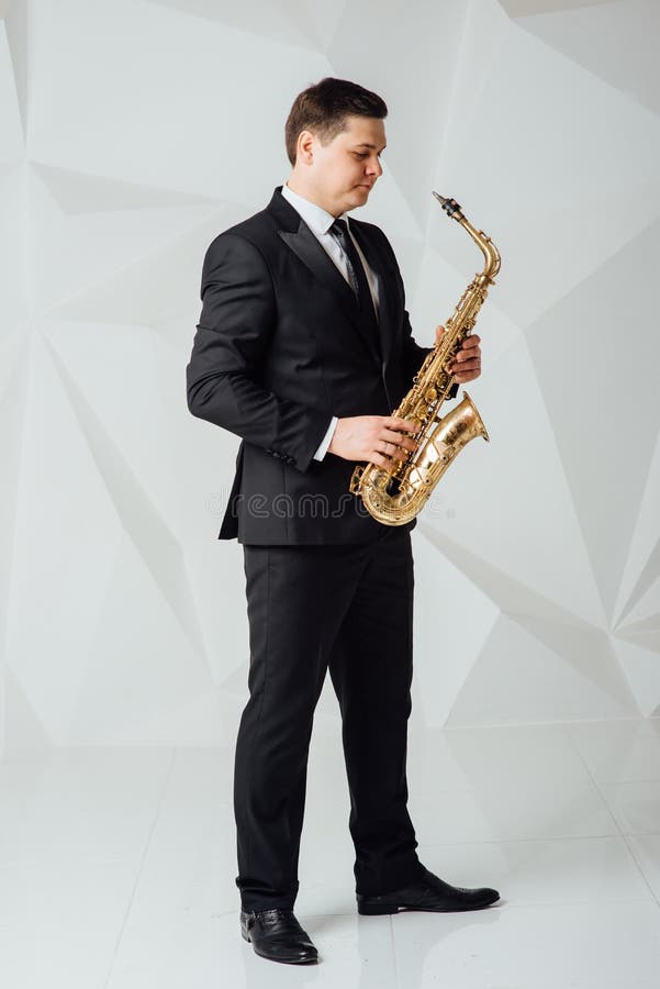 Un hombre juega el cierre del saxofón para arriba imagen de archivo Un hombre juega el cierre del saxofón para arriba imagen de archivo