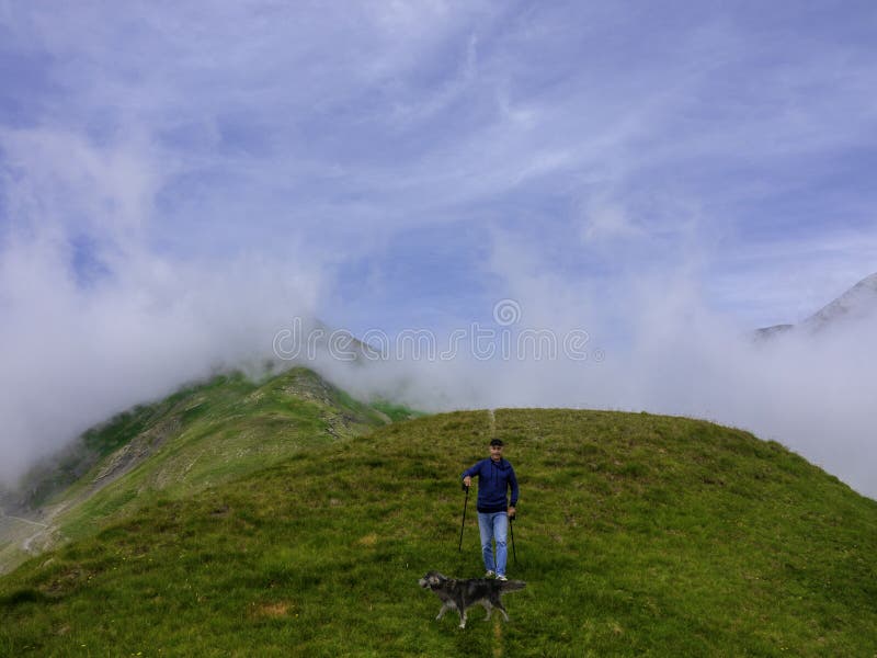 Un hombre mayor activo hace los paseos en las montañas con su perro imágenes de archivo libres de regalías Un hombre mayor activo hace los paseos en las montañas con su perro imágenes de archivo libres de regalías