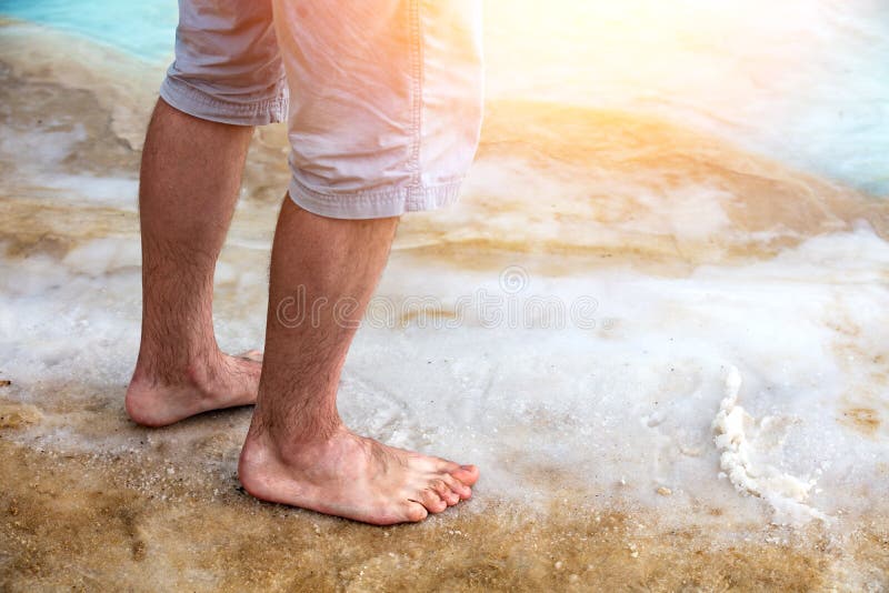 Un hombre que camina en la playa del mar muerto imagenes de archivo Un hombre que camina en la playa del mar muerto imagenes de archivo