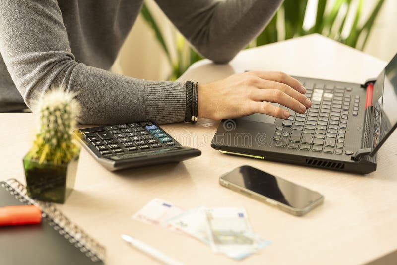 A man works on a laptop at his workplace. A man works on a laptop at his workplace.